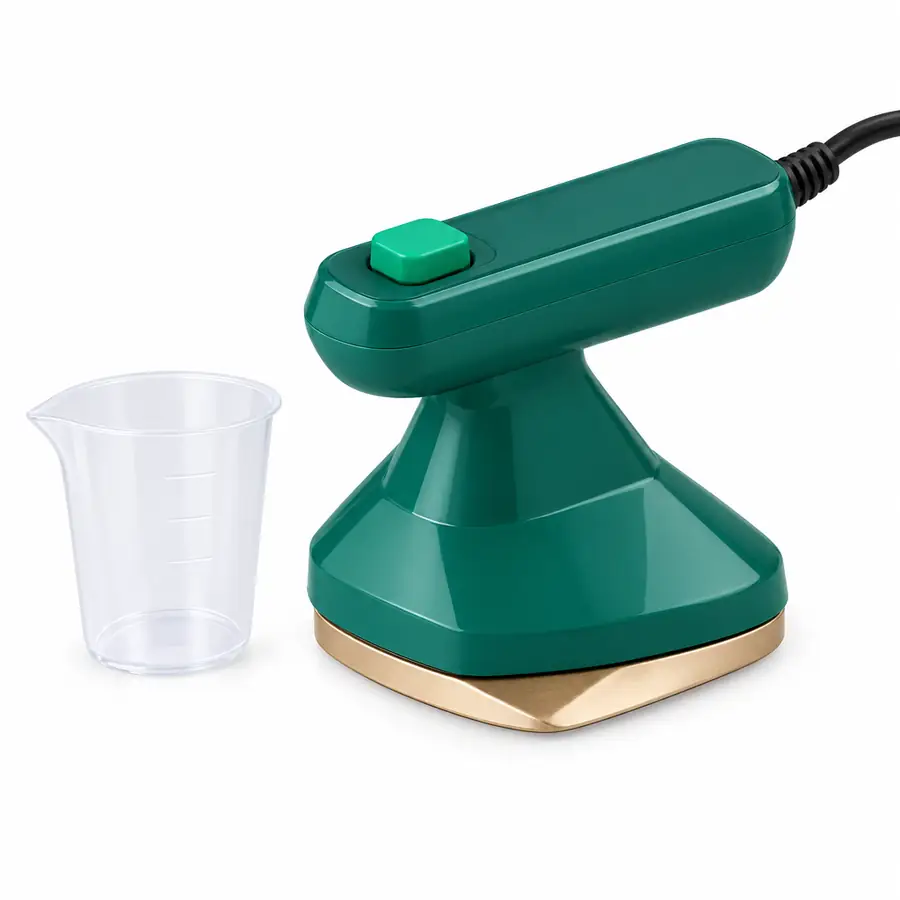 Mini plancha a vapor verde con suela dorada y su vasito, sobre fondo blanco